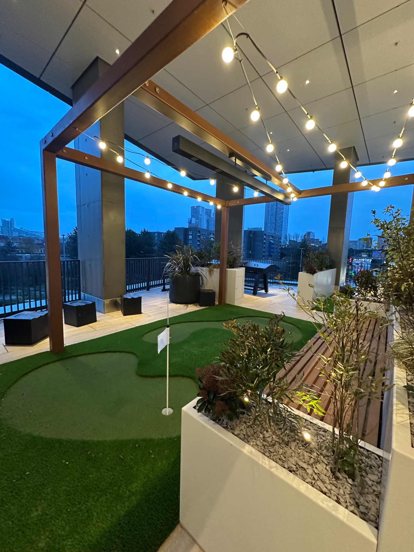 Vista River Gardens putting green and pergola terrace at dusk